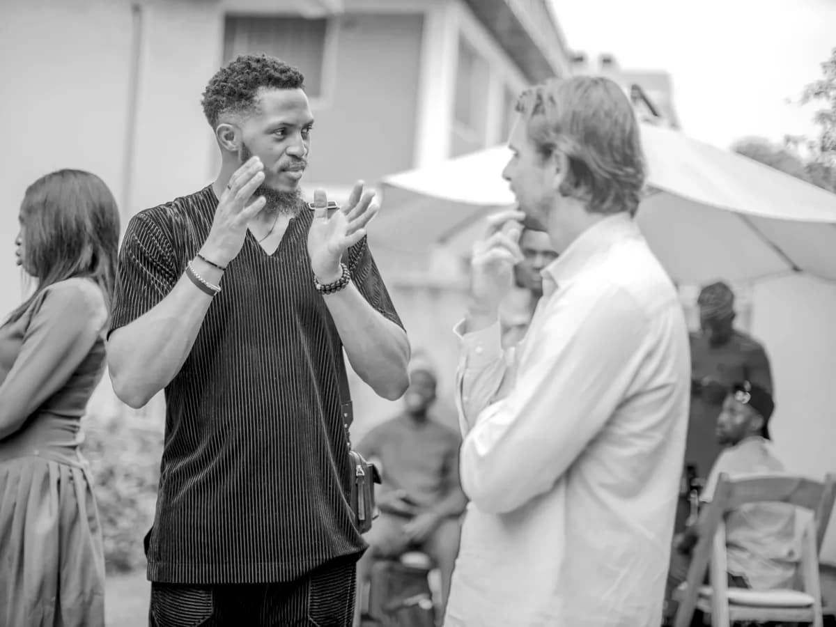 Two people in conversation at a 390 gathering, one of them gesturing mid-sentence.